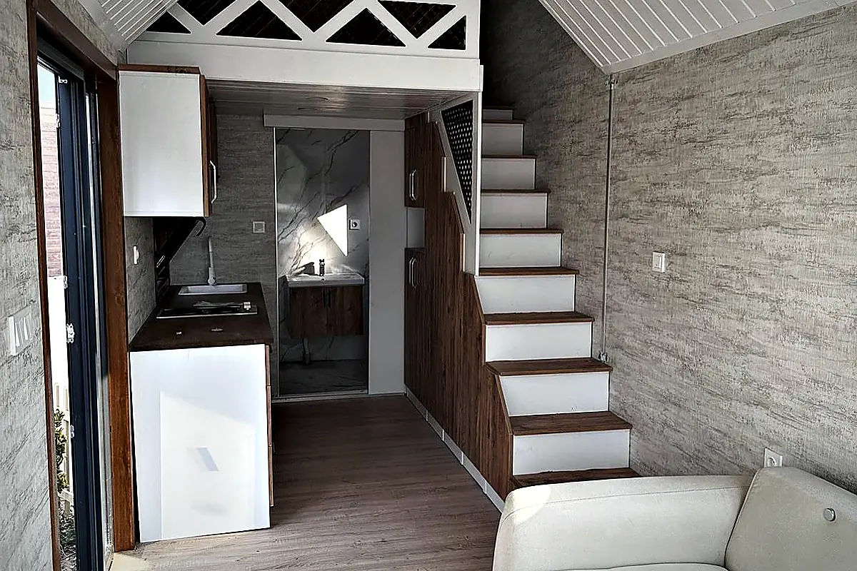 Wohnbereich mit Sofa und offener Treppe zum Obergeschoss